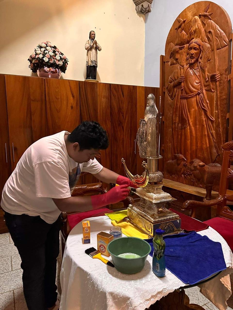 Manos del maestro orfebre trabajando una pieza de arte sacro
